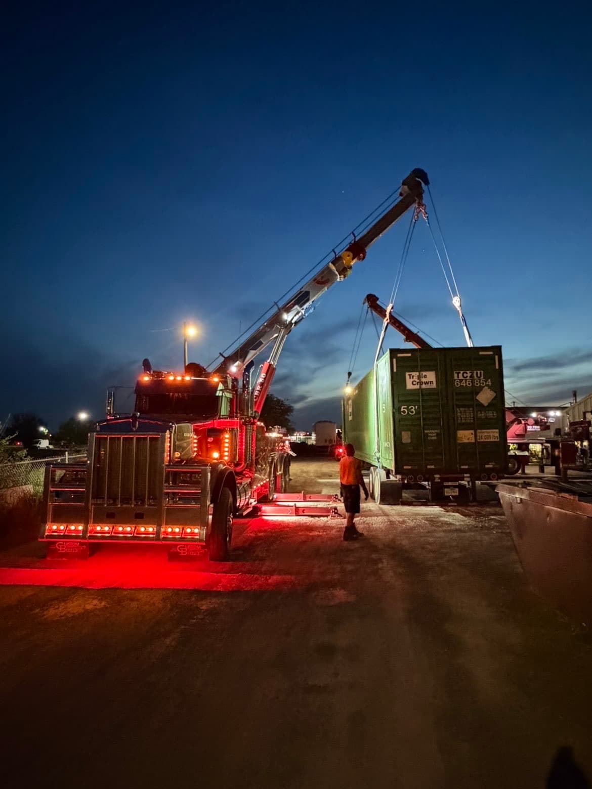 Heavy duty wrecker lifting shipping container at night — Northwest Ohio